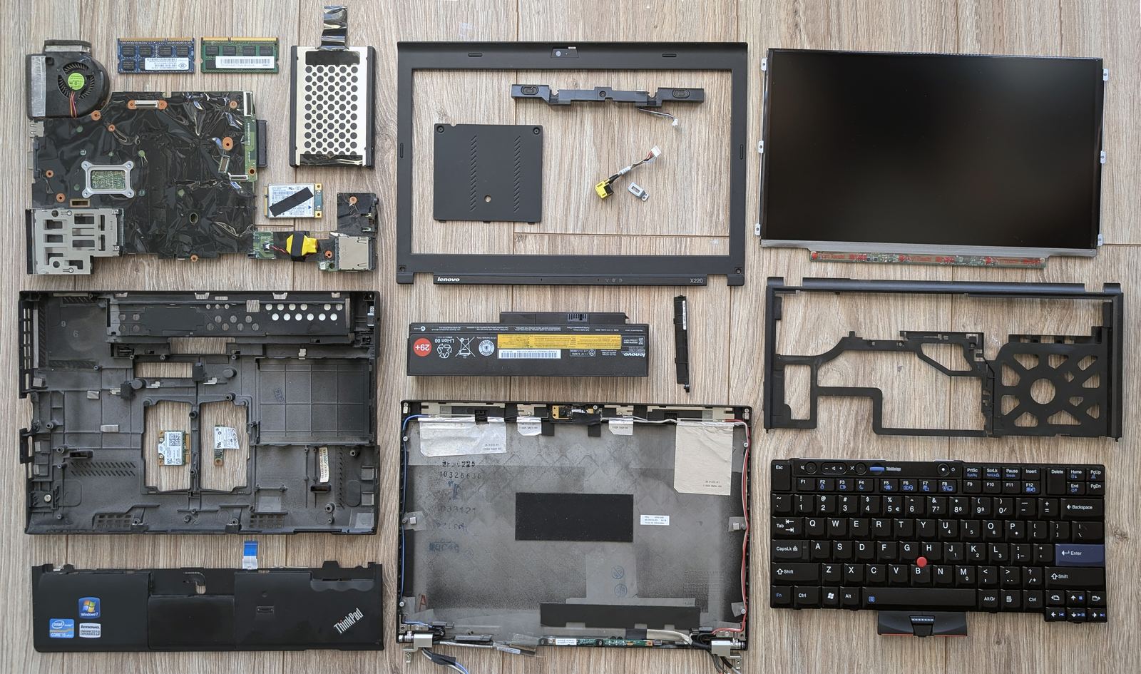 A disassembled ThinkPad laptop with its parts laid out.